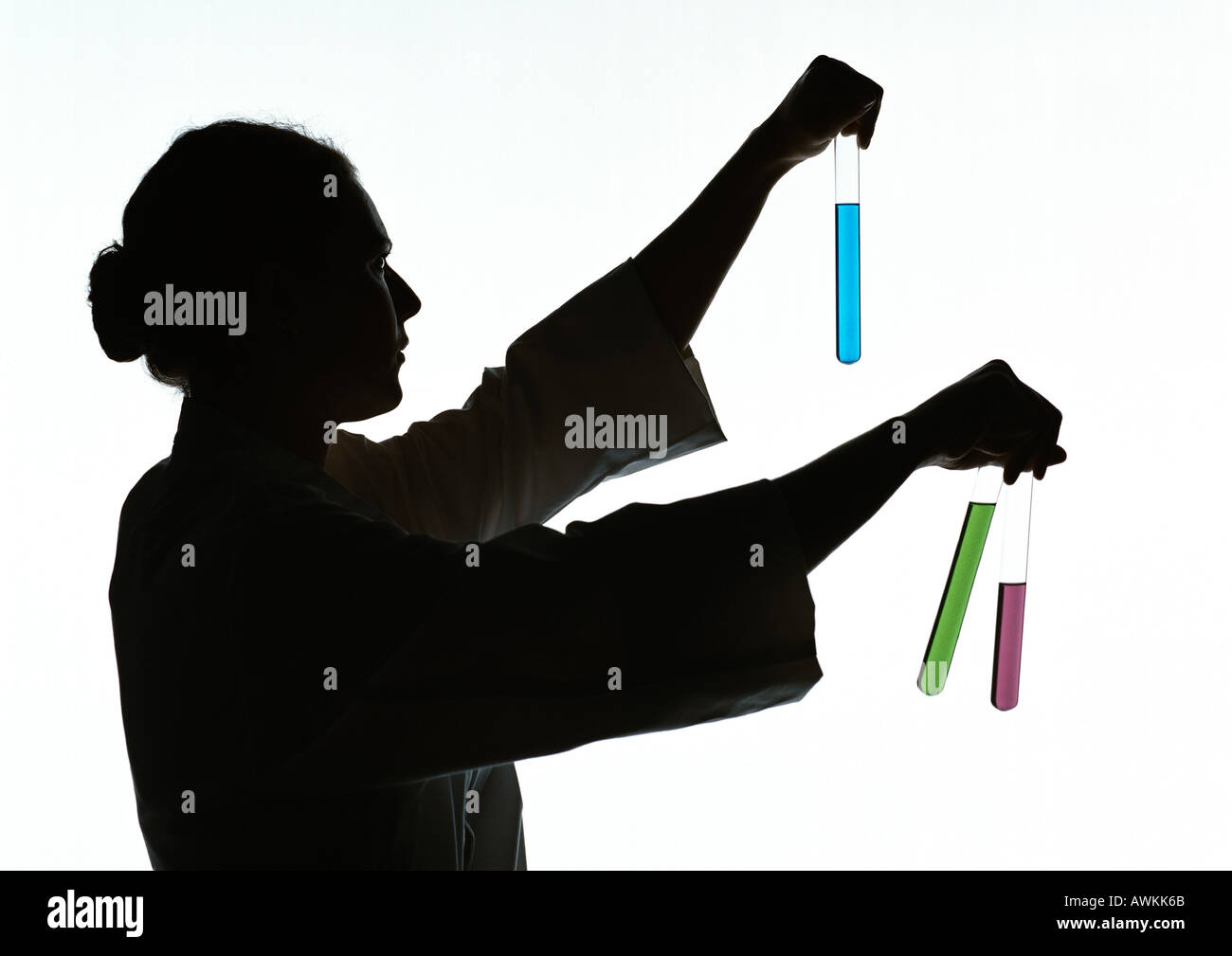 Donna che mantiene le provette contenenti diversi liquidi colorati, silhouette. Foto Stock