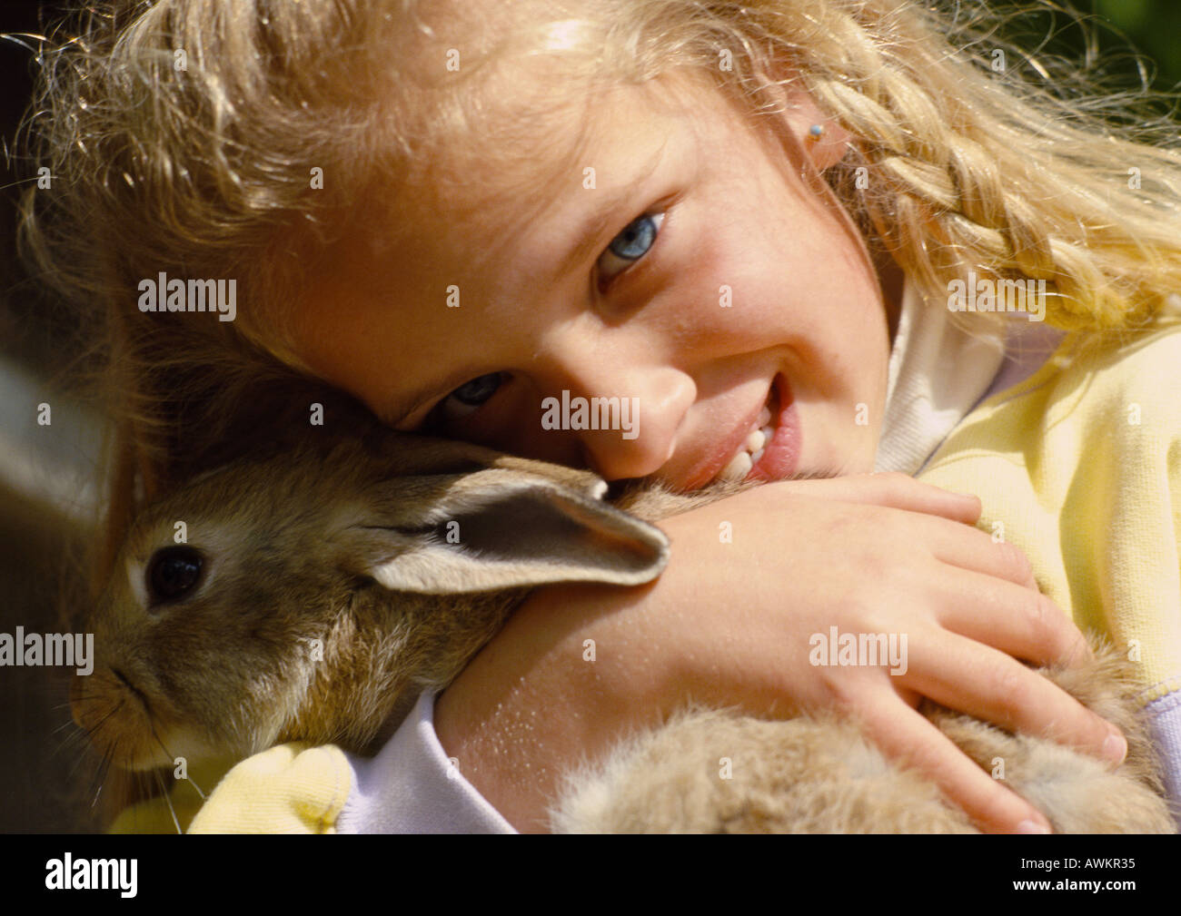Ragazza abbracciando il coniglio, close-up Foto Stock
