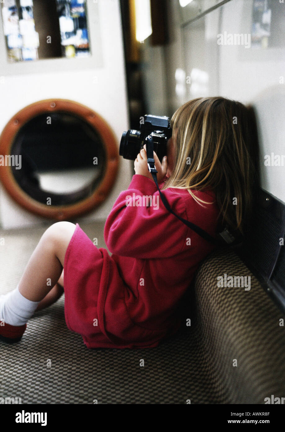 Bambina sul divano tenere la fotocamera Foto Stock