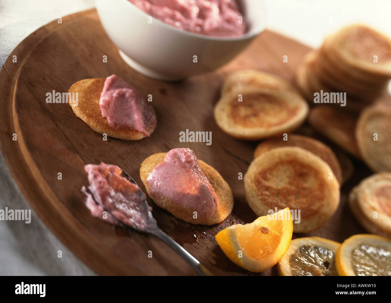 Blinis e taramasalata sulla rotonda di legno con fettina di limone, close-up Foto Stock