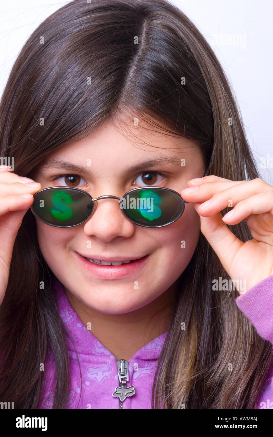 Giovane ragazza che indossa un paio di occhiali di divertimento con segni di dollaro sulle lenti Foto Stock
