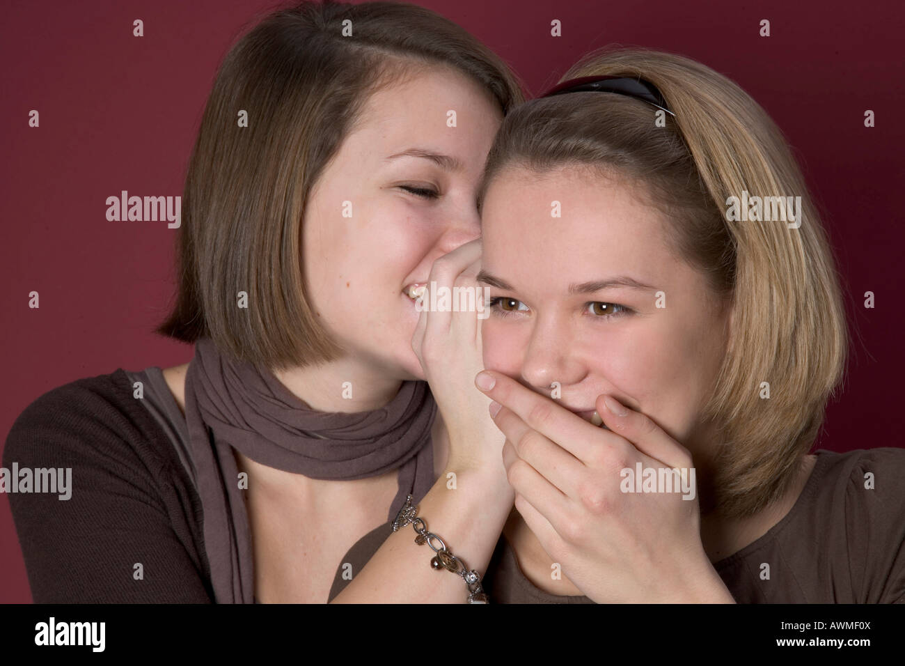 Due ragazze, pre-adolescenti, early teens whispering a ciascun altro Foto Stock