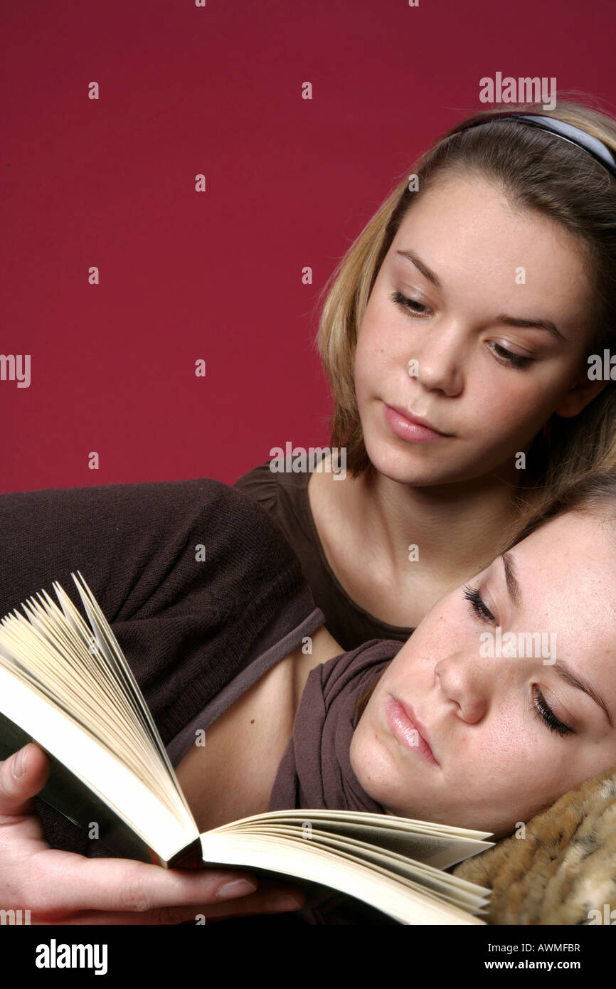 Due ragazze, pre-adolescenti, dai primi anni dell'adolescenza la lettura di un libro insieme Foto Stock