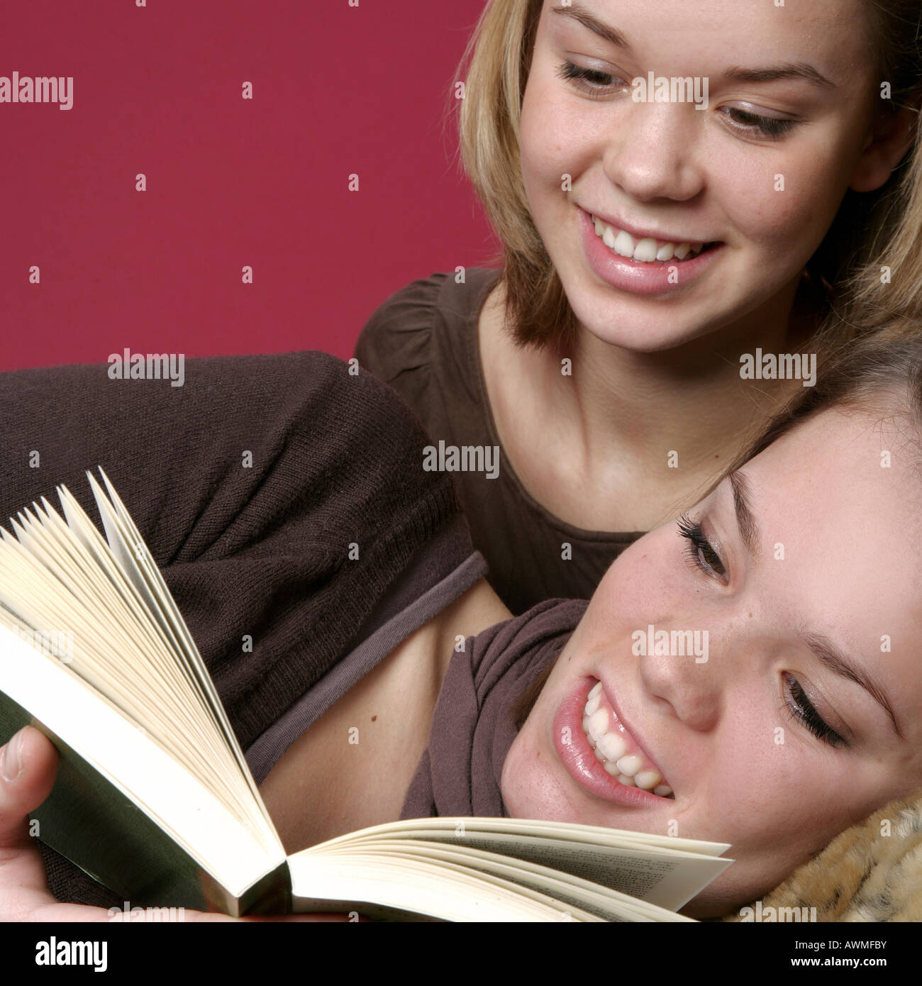Due ragazze, pre-adolescenti, dai primi anni dell'adolescenza la lettura di un libro insieme Foto Stock