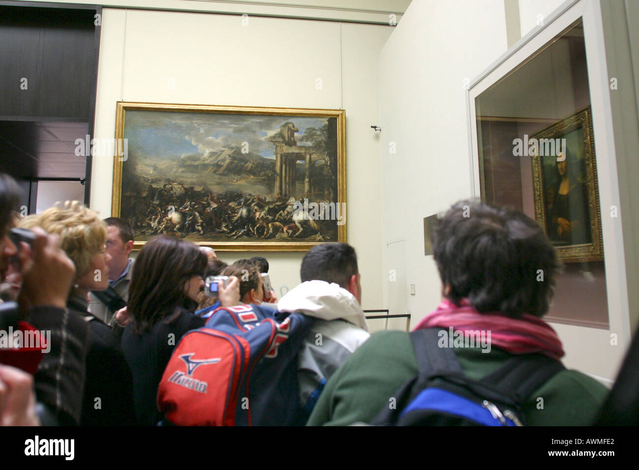 I turisti in cerca di dipingere la Mona Lisa di Leonardo da Vinci sul display dietro la sua bullet proof schermo nell'arte del Louvre Foto Stock