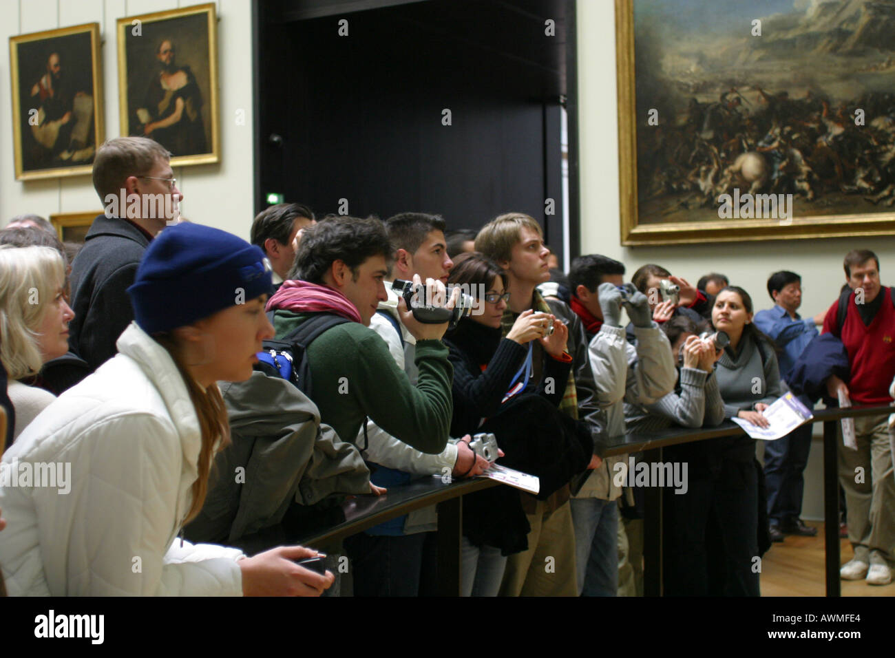 I turisti in cerca di dipingere la Mona Lisa di Leonardo da Vinci sul display dietro la sua bullet proof schermo nell'arte del Louvre Foto Stock