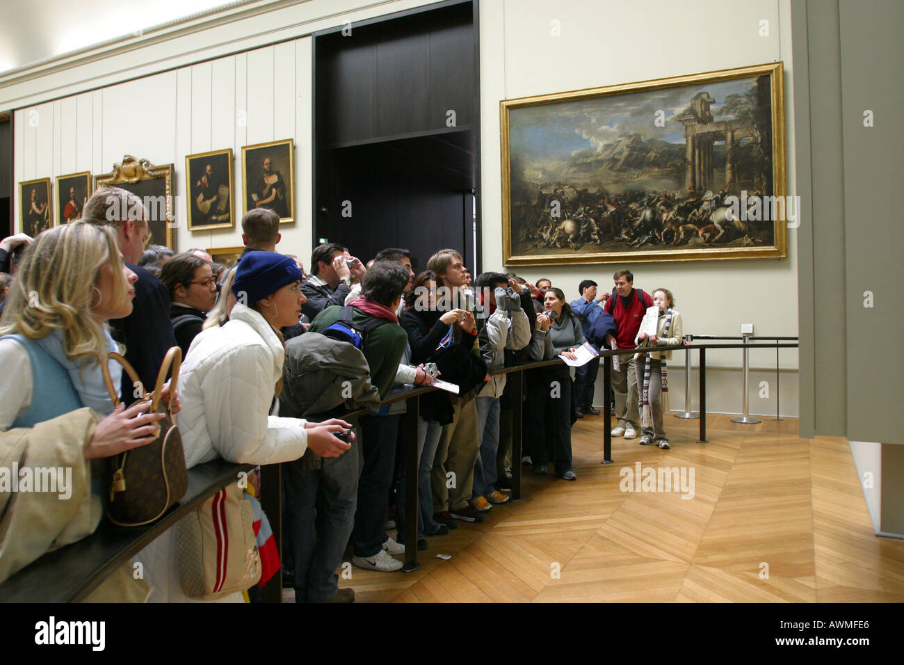 I turisti in cerca di dipingere la Mona Lisa di Leonardo da Vinci sul display dietro la sua bullet proof schermo nell'arte del Louvre Foto Stock