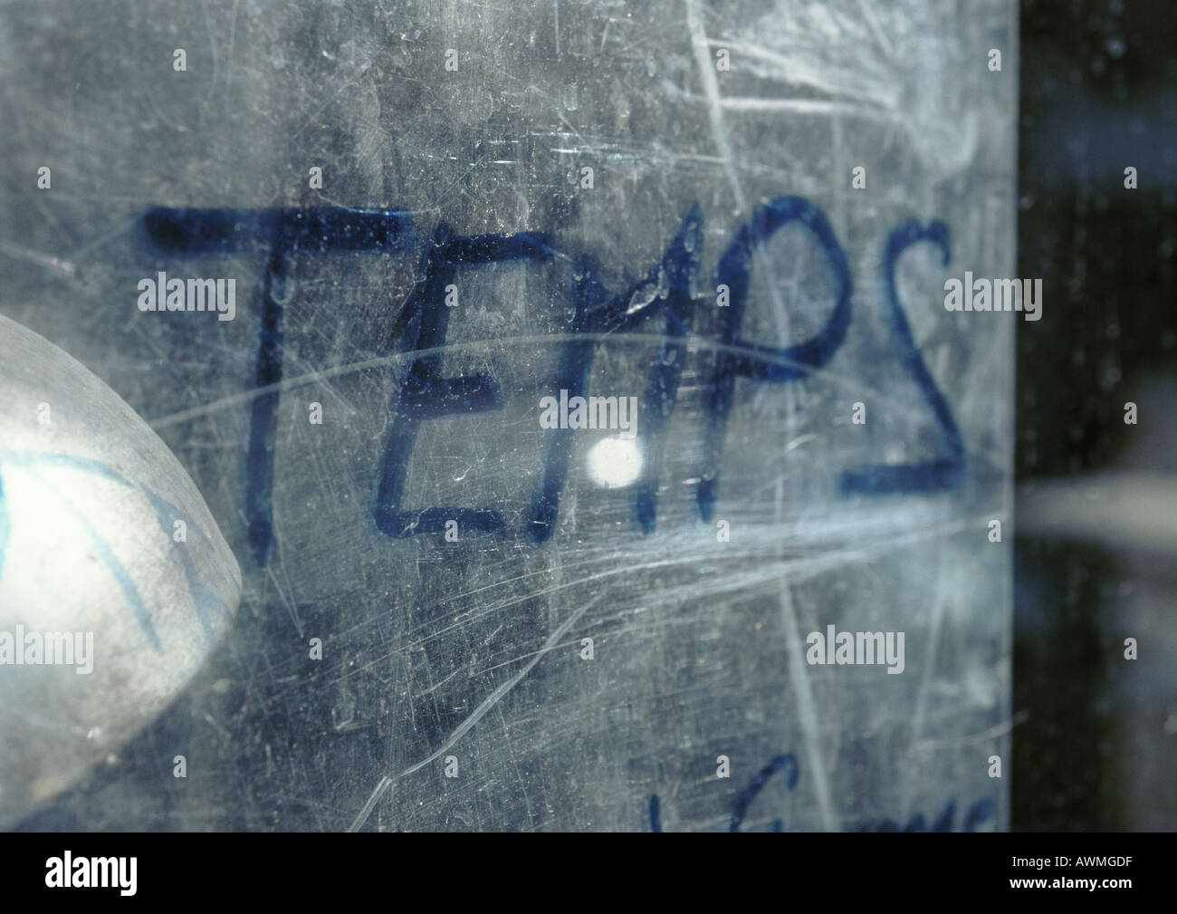 Tempo testo in francese scritta sulla superficie graffiata, close-up Foto Stock