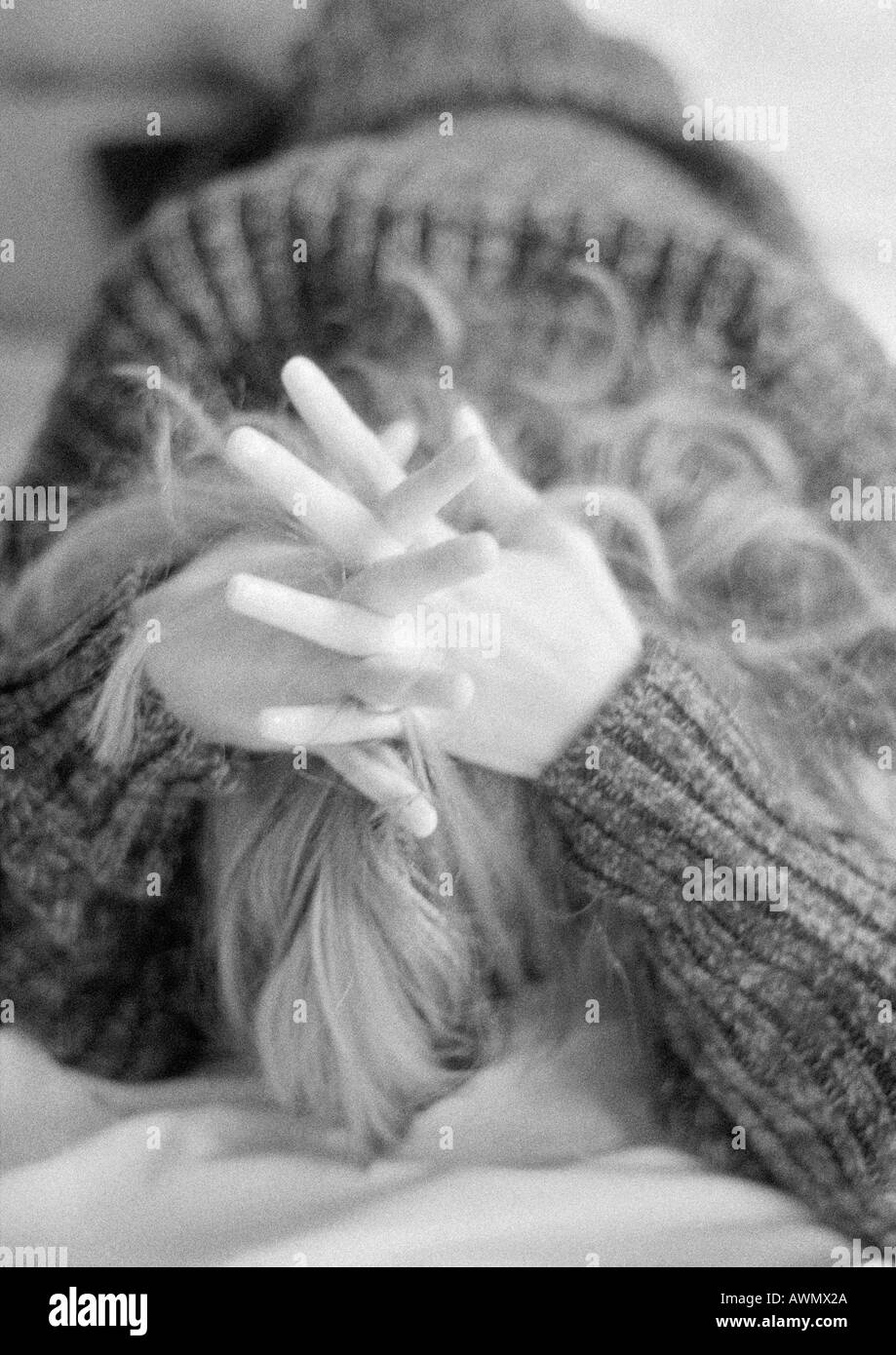 Donna sdraiata sul letto con il lato stampato rivolto verso il basso e le mani incrociate dietro la testa, in bianco e nero Foto Stock