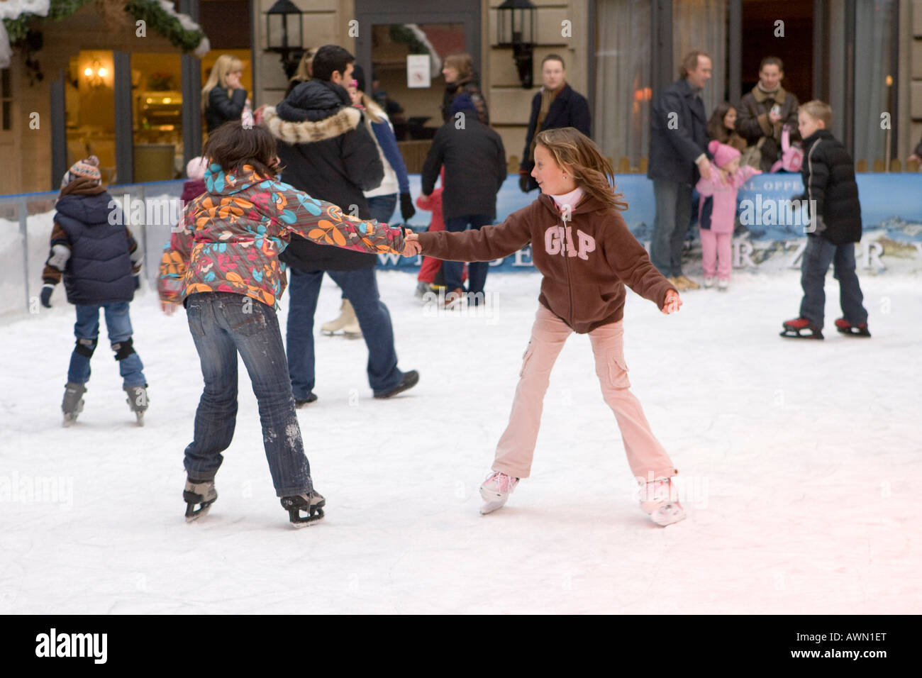 I bambini a pattinare sulla pista di pattinaggio artificiale nel centro della città, tenendo reciprocamente le mani, Francoforte Hesse, Germania, Europa Foto Stock