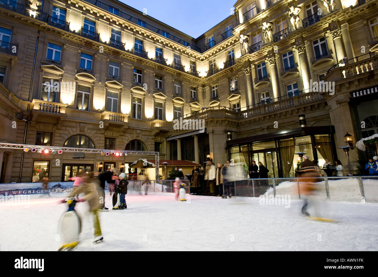 I bambini a pattinare sulla pista di pattinaggio artificiale nel centro della città a Steigenberger-Frankfurter Hof Hotel, Francoforte Hesse, Germania, e Foto Stock