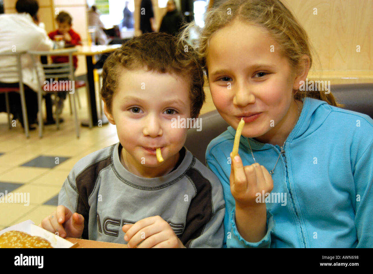 Fratello e Sorella di mangiare Mcdonald's French fries, England, Regno Unito Foto Stock