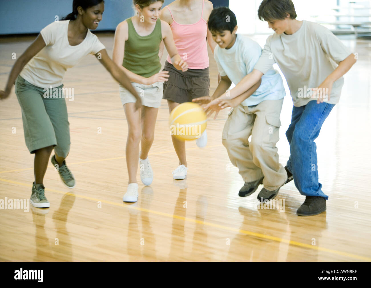 Gli studenti delle scuole superiori a giocare a basket in palestra della scuola Foto Stock