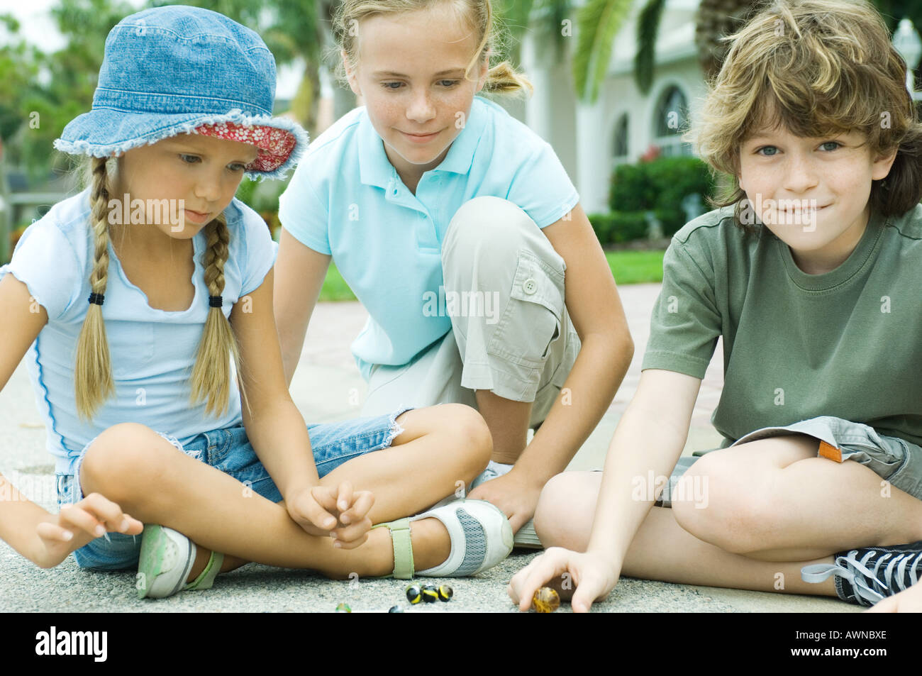 Bambini che giocano marmi in strada residenziale Foto Stock