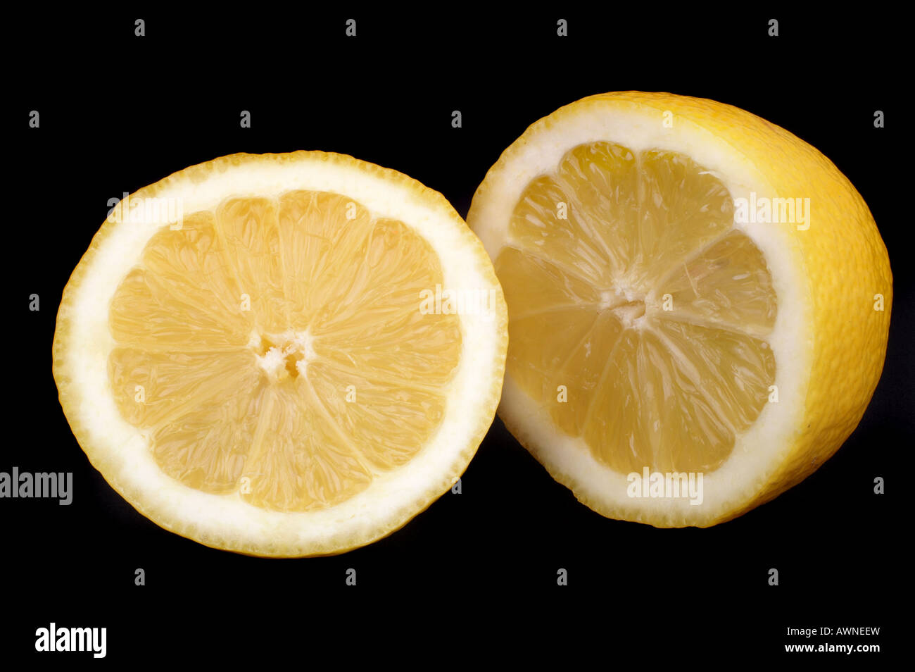 Aufgeschnittene Limone vor schwarzem Hintergrund / giallo limone tagliato in due metà Foto Stock