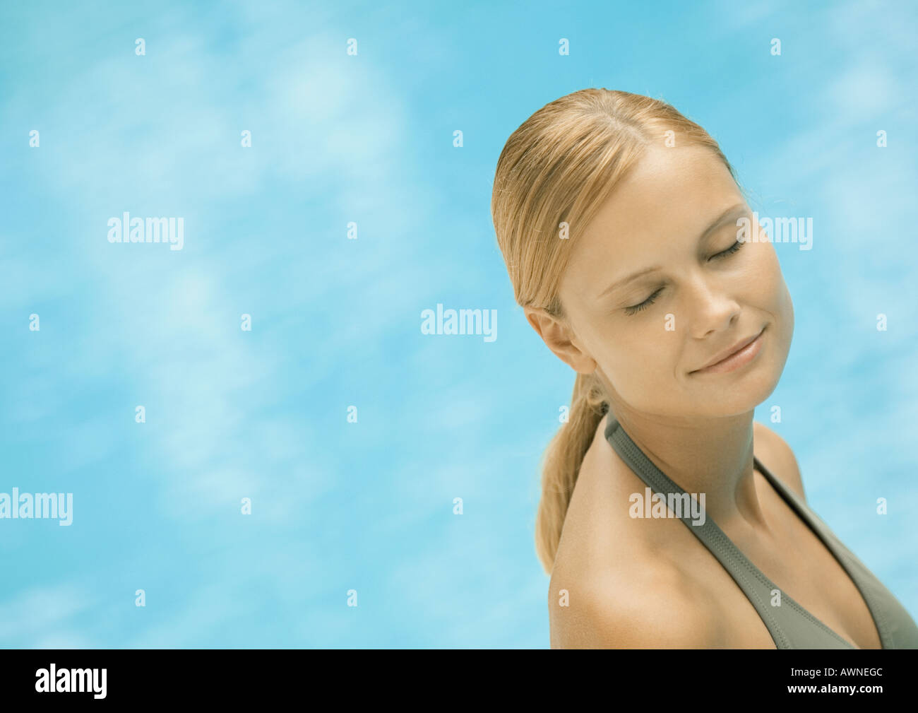 Donna sorridente con gli occhi chiusi, acqua in background Foto Stock