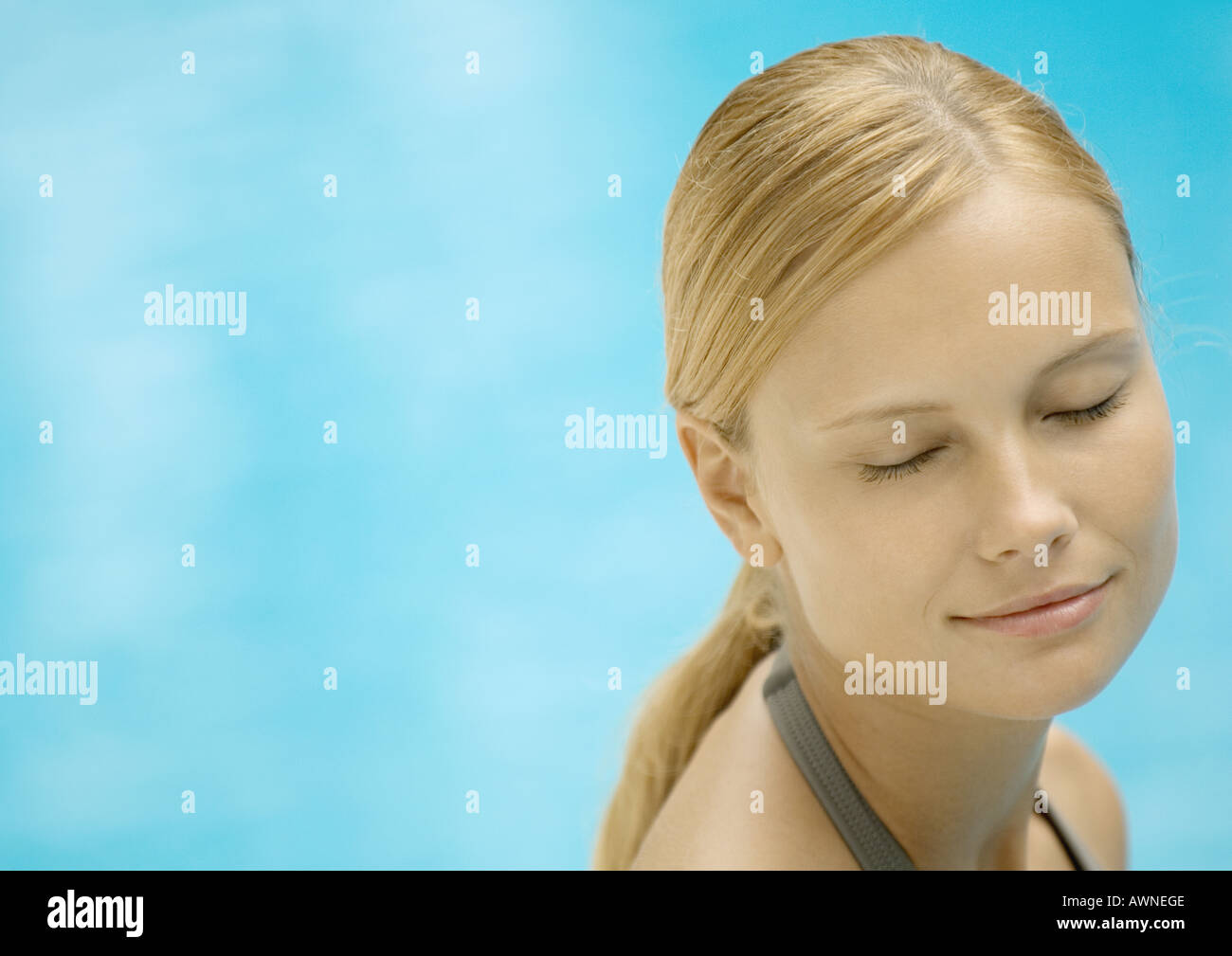 Donna sorridente con gli occhi chiusi, acqua in background Foto Stock