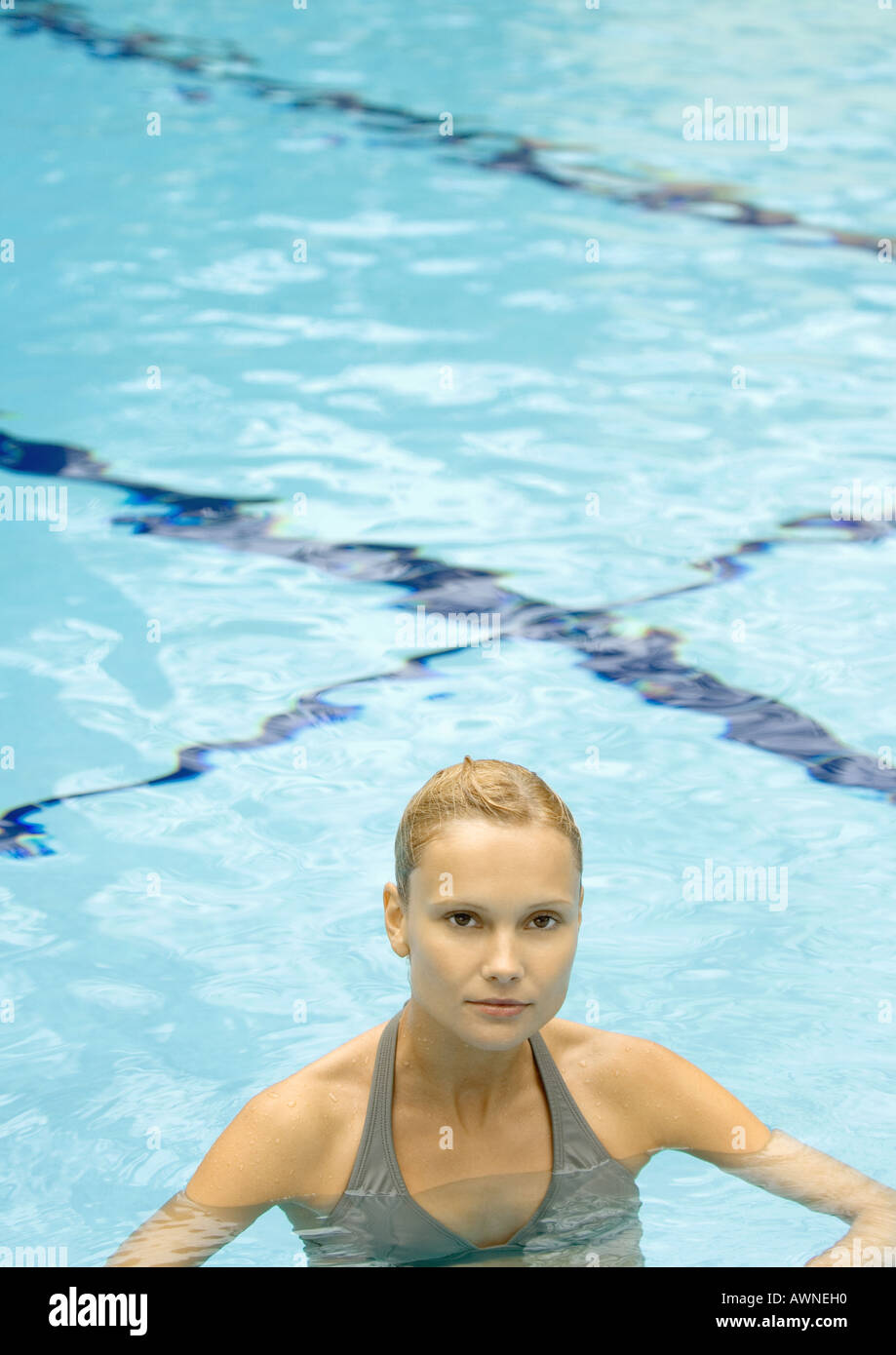 Donna in piedi in piscina, guardando la fotocamera Foto Stock