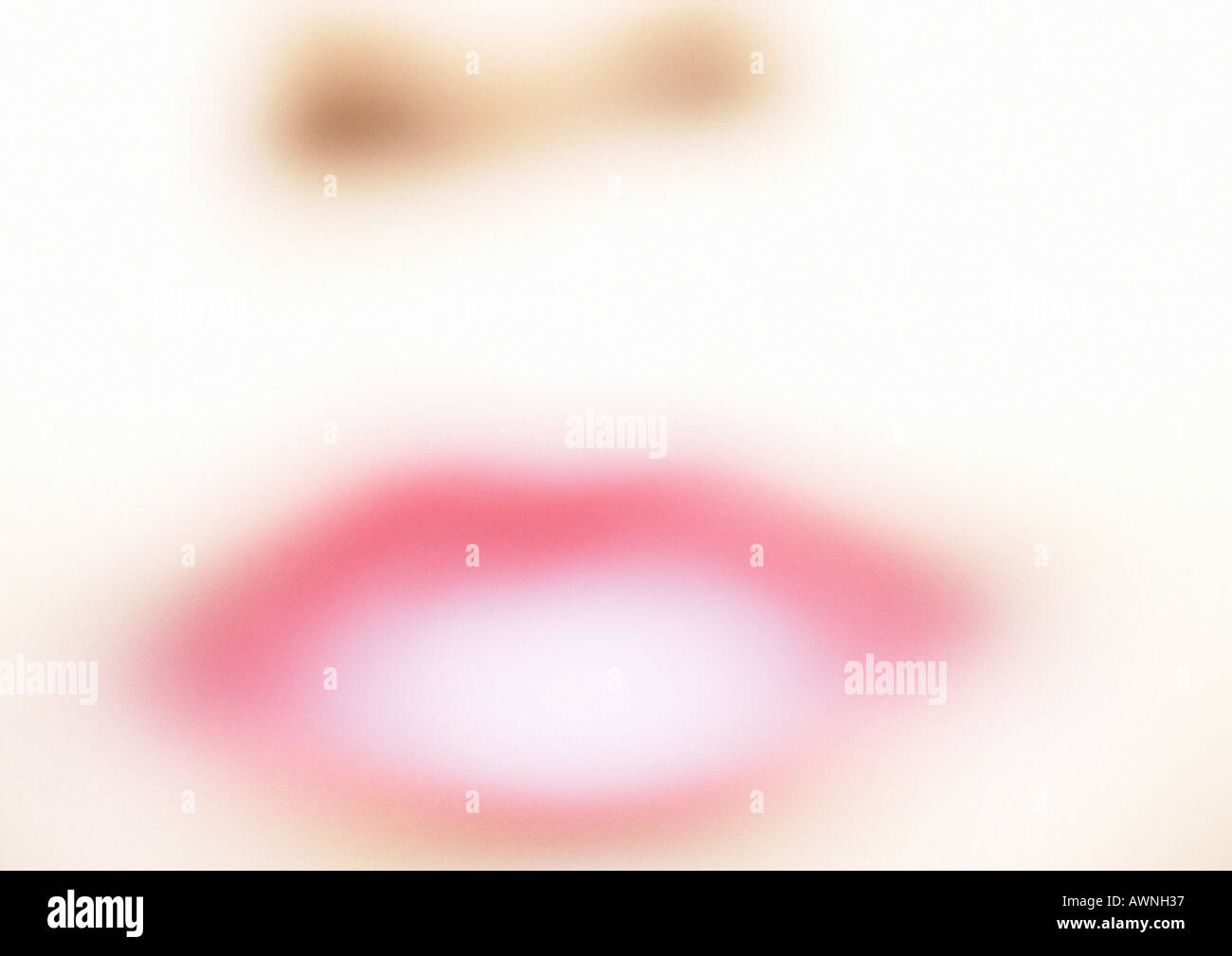 Donna che indossa un rossetto rosa, in prossimità della bocca, sfocata. Foto Stock