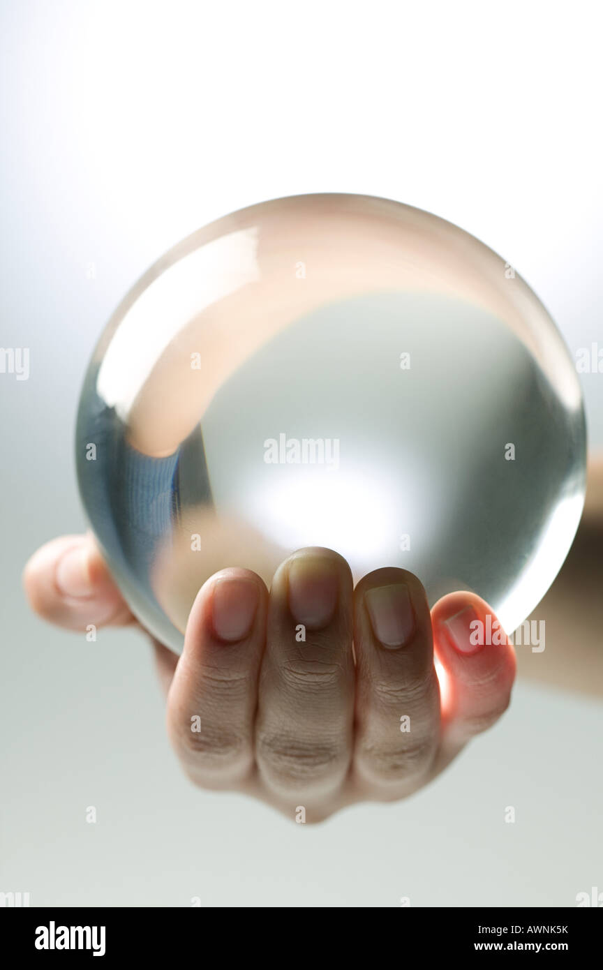 Una persona in possesso di una sfera di cristallo Foto Stock