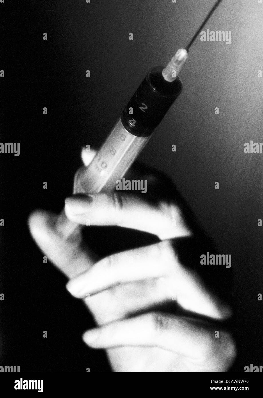 Mano che tiene la siringa, close-up, B&W Foto Stock