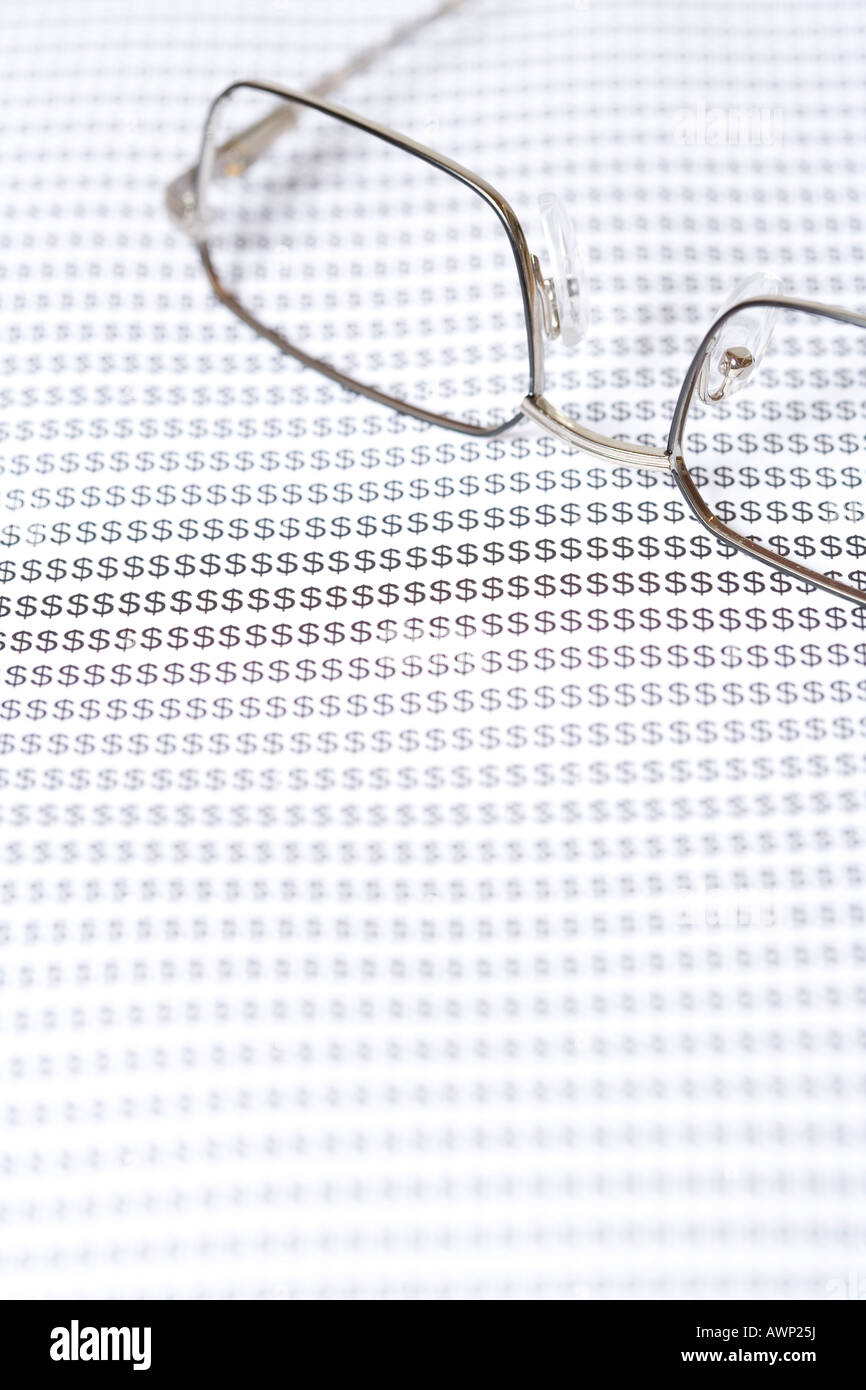 Occhiali da vista sullo sfondo con segni di dollaro Foto Stock