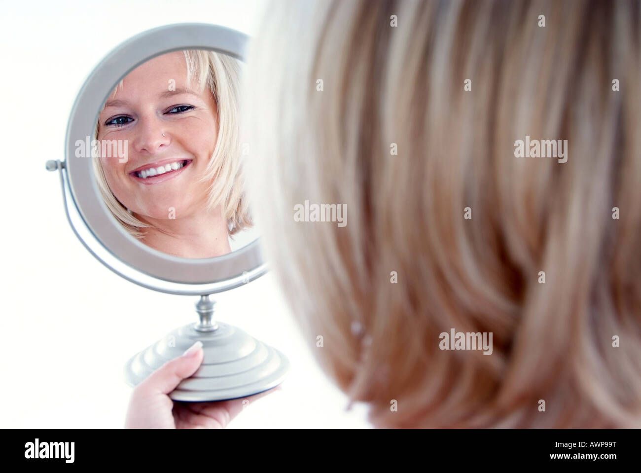 Donna che guarda in specchio Foto Stock