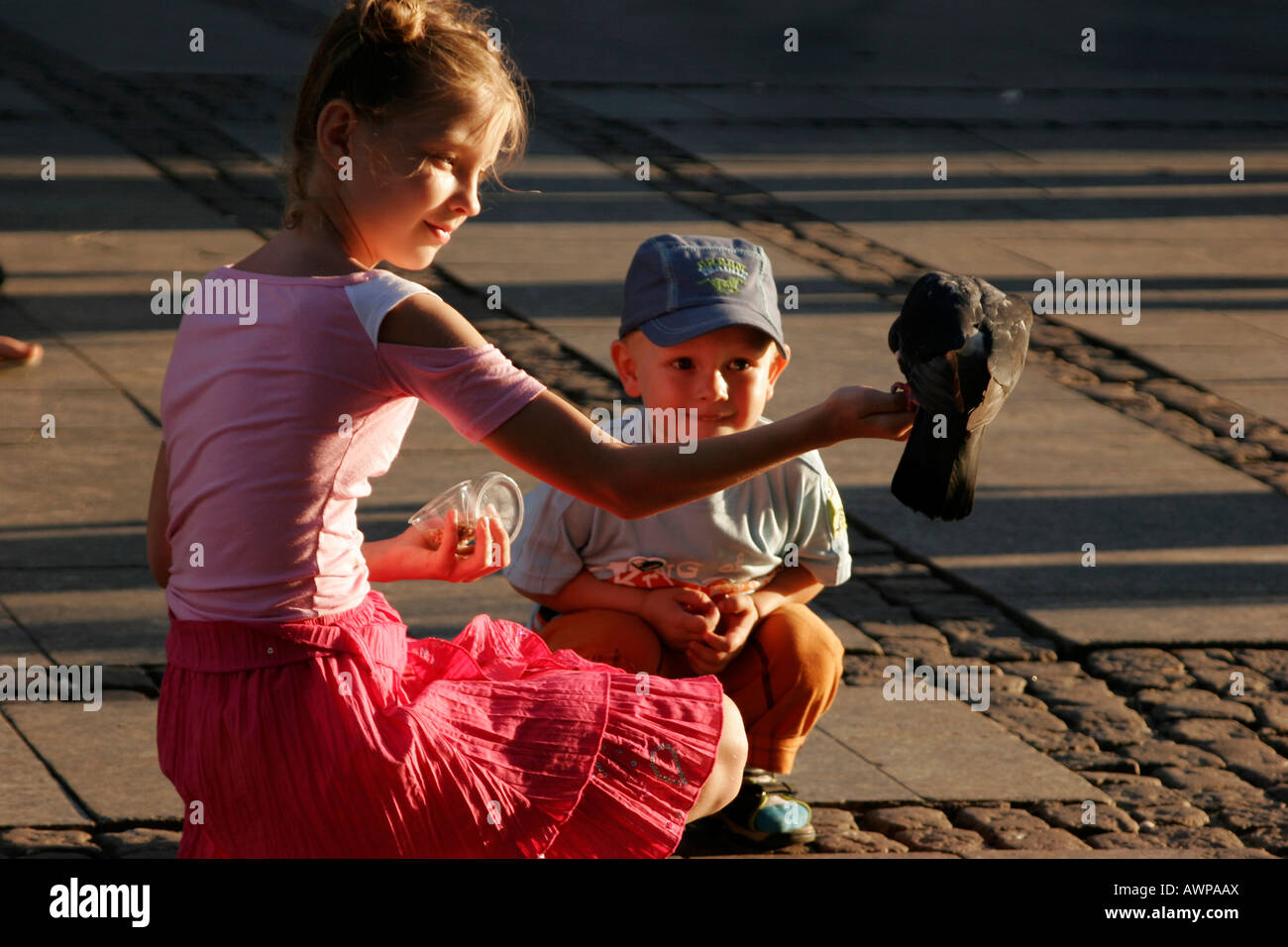 Alimentazione bambini piccioni in centro storico di Danzica, Polonia, Europa Foto Stock