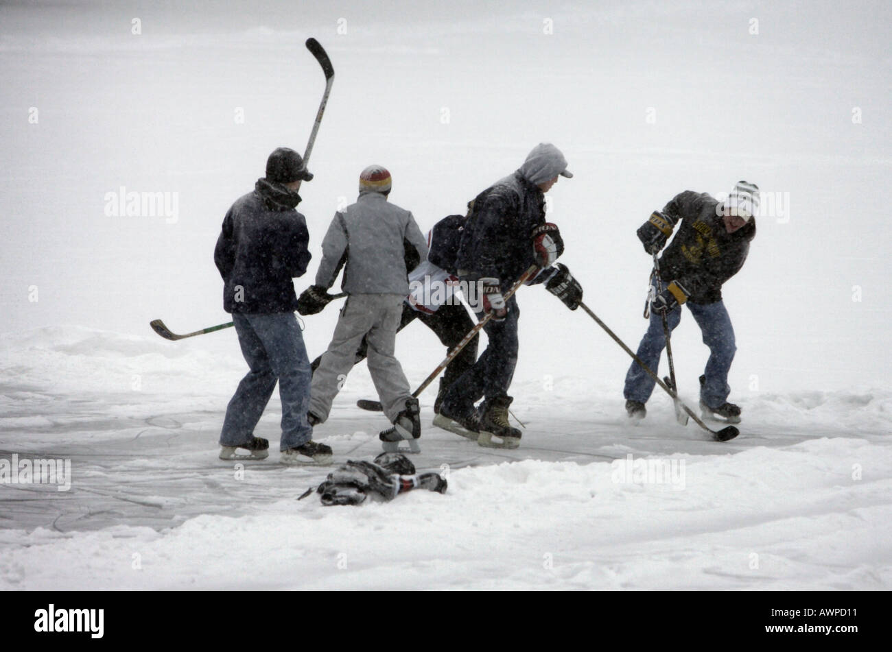 Ragazzi giocare hockey su ghiaccio su un laghetto congelato Foto Stock