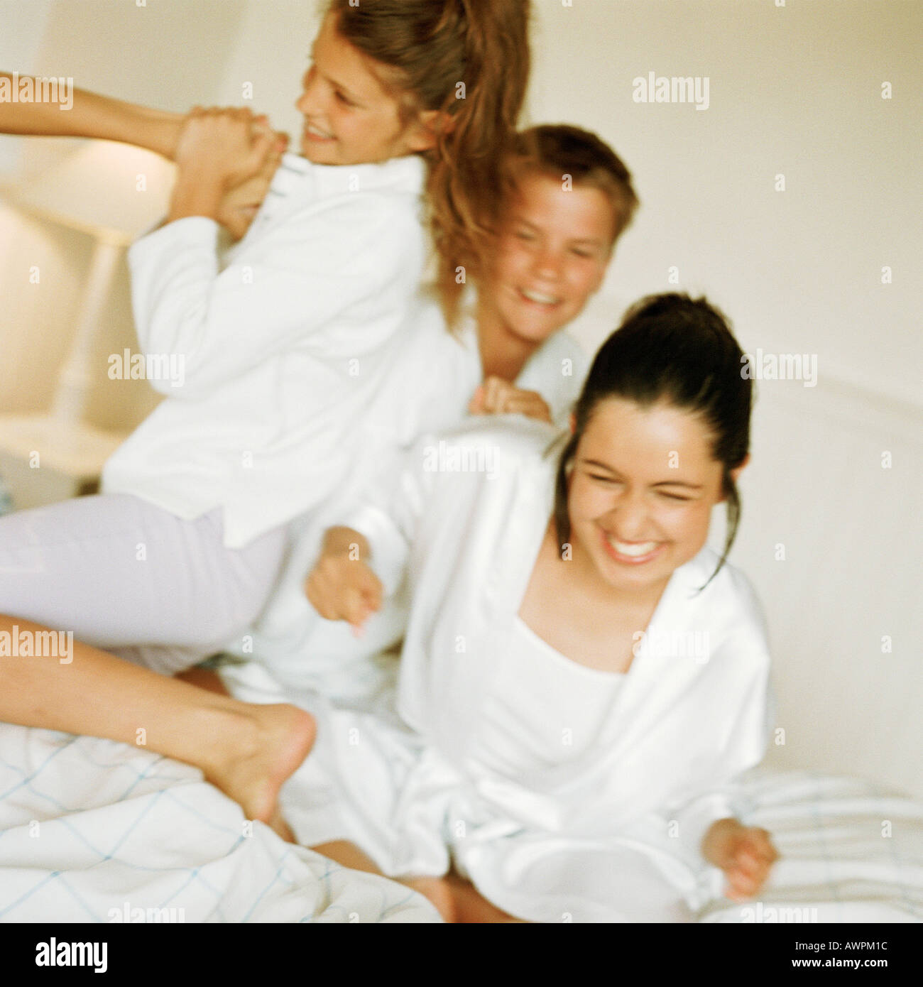 Giovani playfighting sul letto, sorridente Foto Stock