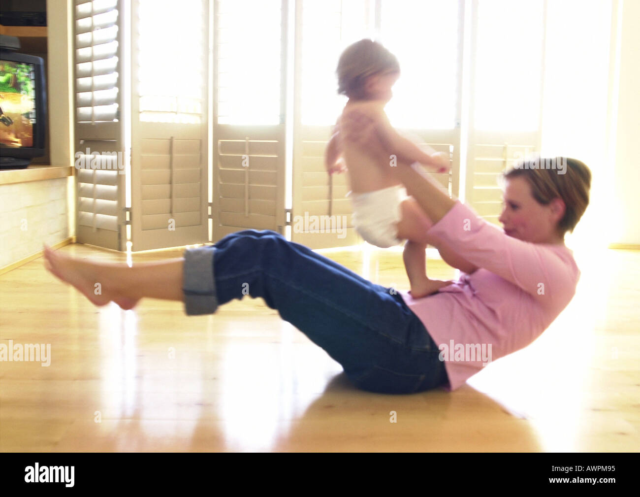 Donna sul pavimento, tenendo baby Foto Stock