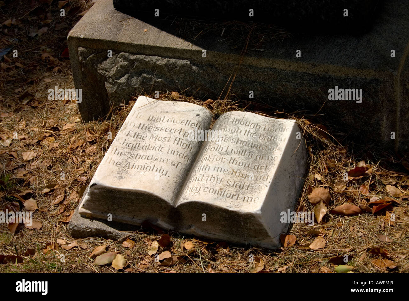 La scultura in pietra di una Bibbia aperta al salmo 23 versetto, ai piedi di una pietra tombale. Foto Stock