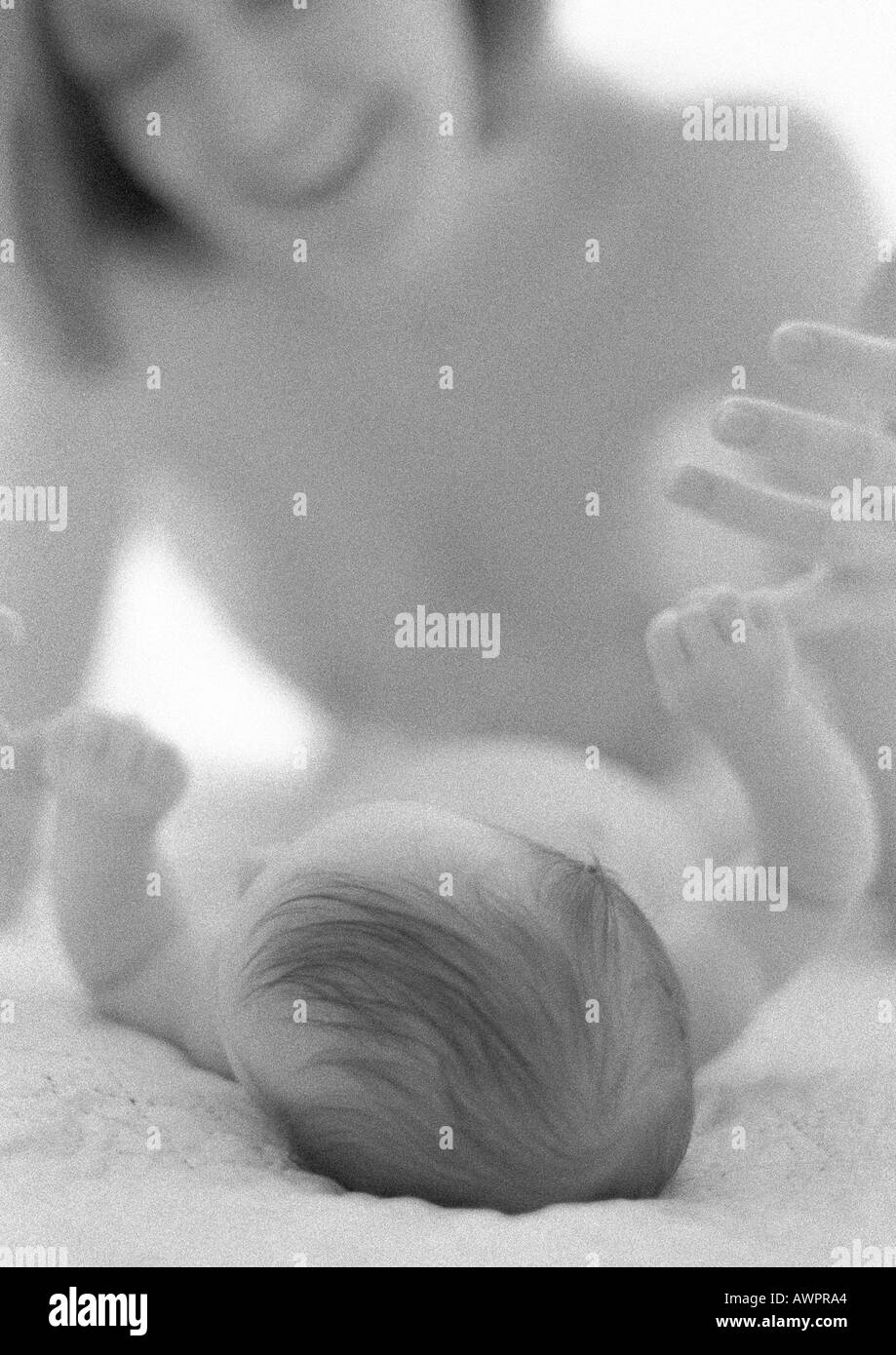 Neonato sdraiato azienda madre del dito con la mano, b&W Foto Stock