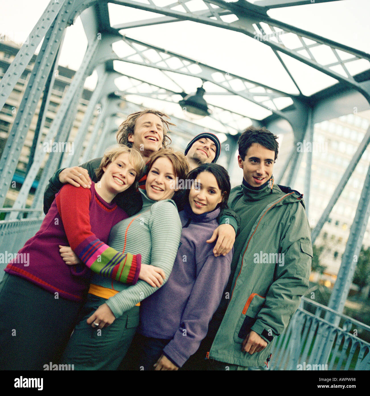 Un gruppo di giovani uomini e donne con le braccia intorno a ciascun altro Foto Stock