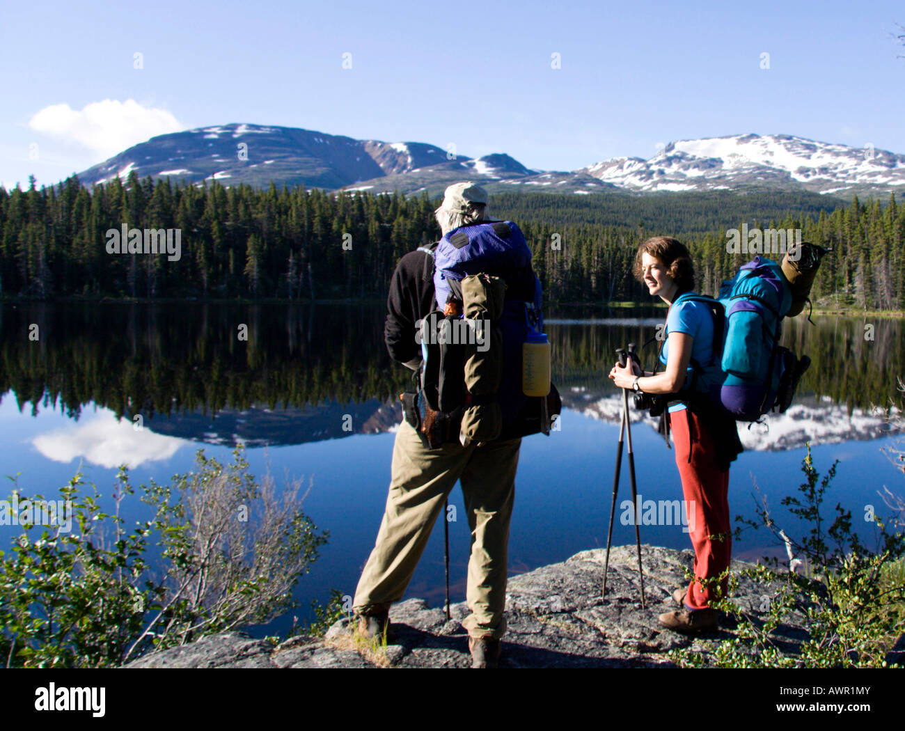 Gli escursionisti godendo di una vista del vitreo Dan Johnson Lago, Chilkoot Trail, British Columbia, Canada Foto Stock