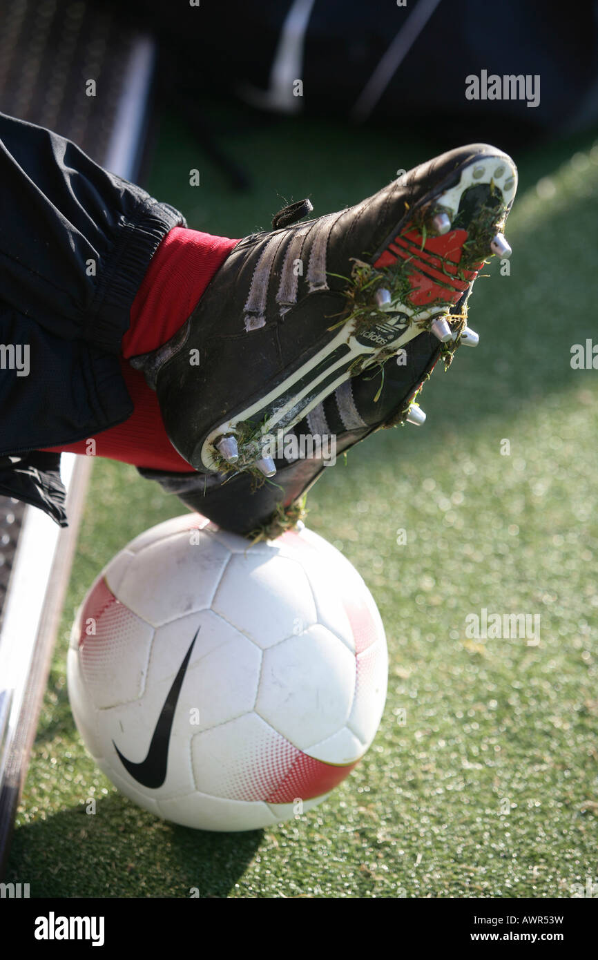 Calzature sportive su un pallone da calcio Foto Stock