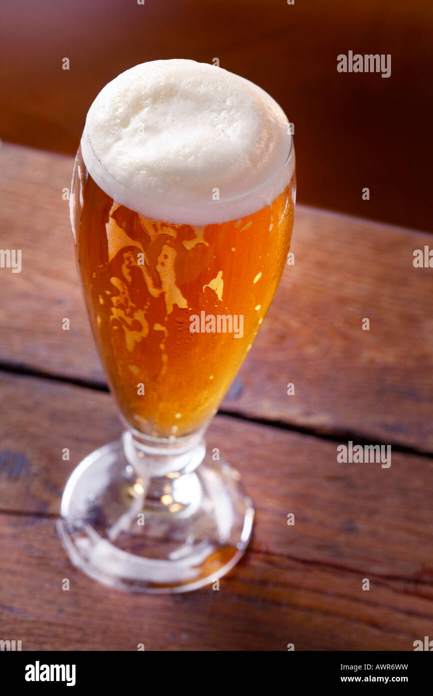 Bicchiere di birra servita su una tavola di legno Foto Stock