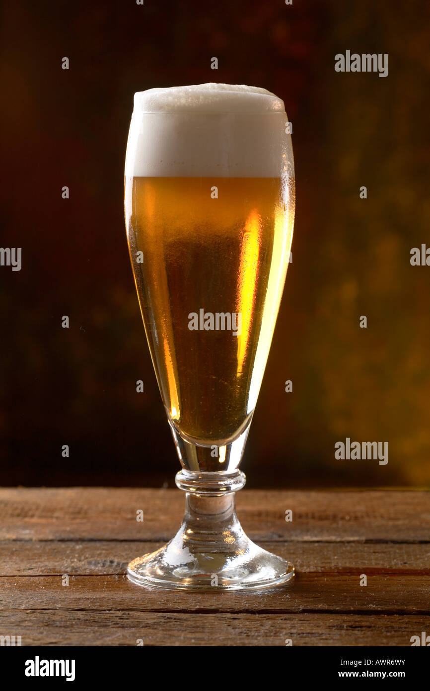 Bicchiere di birra servita su una tavola di legno Foto Stock