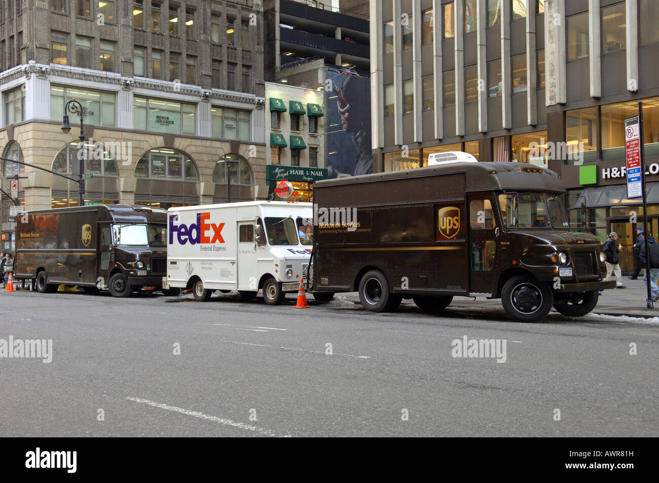 Carrelli UPS circondano un FedEx carrello parcheggiato nel centro di indumento in NYC Foto Stock