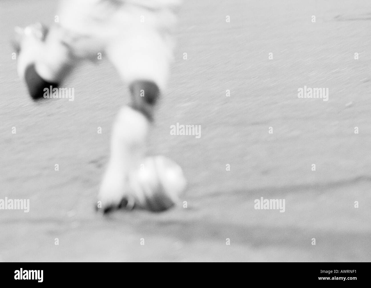 Giocatore di calcio calci palla, offuscata, b&w. Foto Stock