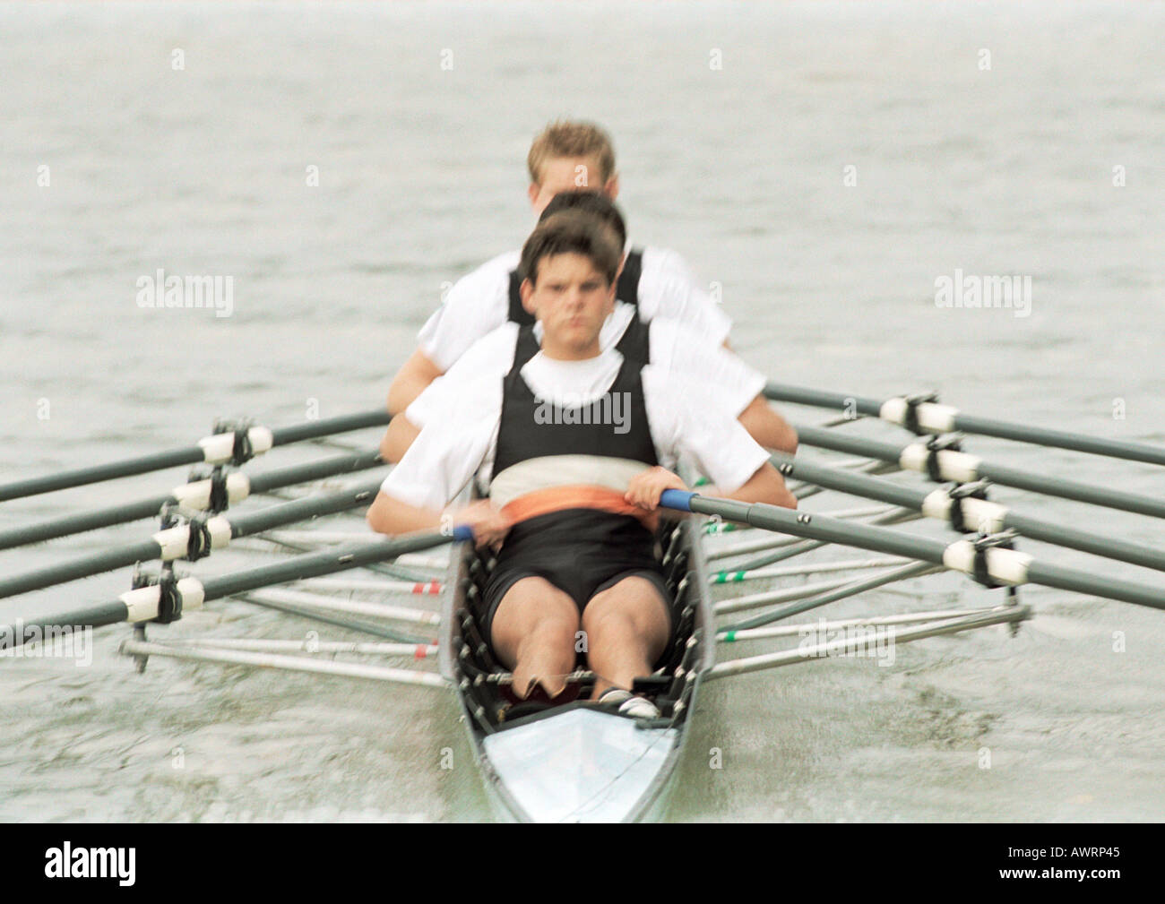 Quattro ragazzi adolescenti equipaggio a remi in barca Foto Stock