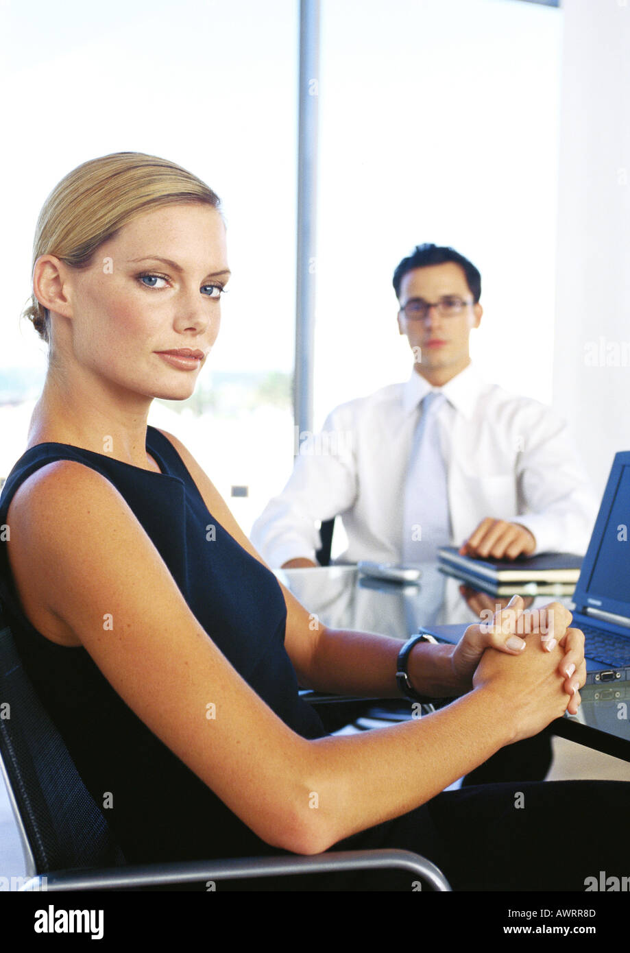 Imprenditore e donna seduta in ufficio, ritratto Foto Stock