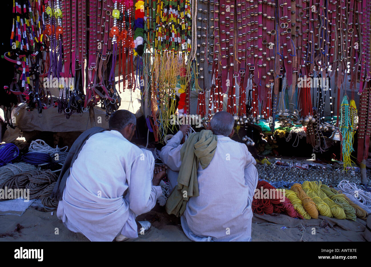 Due uomini di Rajasthani acquisto di accessori per i loro cammelli Pushkar fiera del cammello nel deserto di Thar Rajasthan in India Foto Stock
