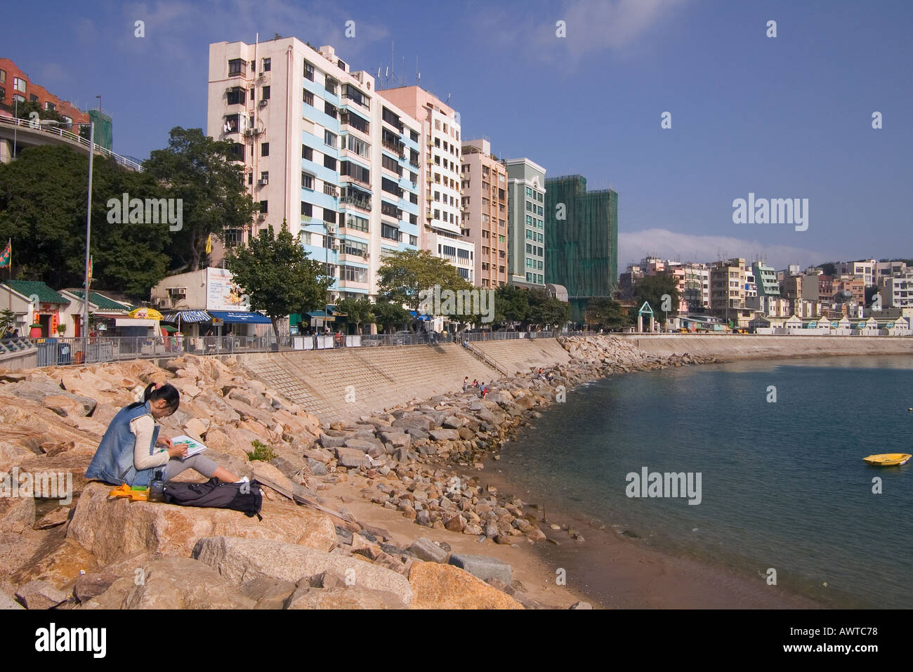 dh Stanley Bay STANLEY HONG KONG giovane ragazza cinese artista seduto disegno villaggio lungomare appartamento blocco appartamento teenage pittura Foto Stock