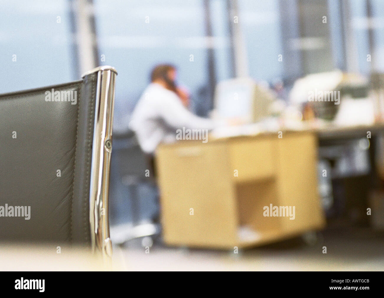 Imprenditore seduto alla scrivania parlando al telefono, sfocata. Foto Stock
