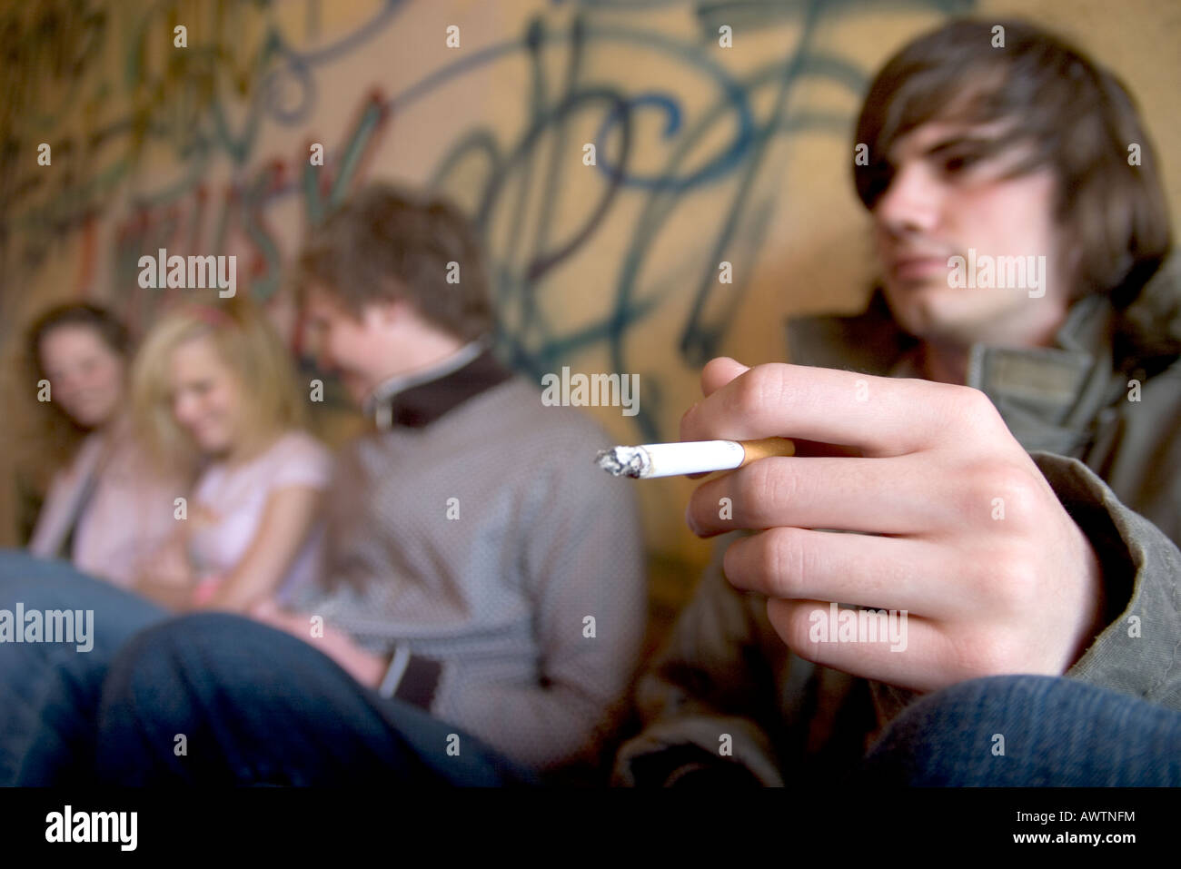 Immagine concettuale delle questioni sanitarie e sociali legate all'adolescenza fumo (giovane attore che simula il fumo) Foto Stock