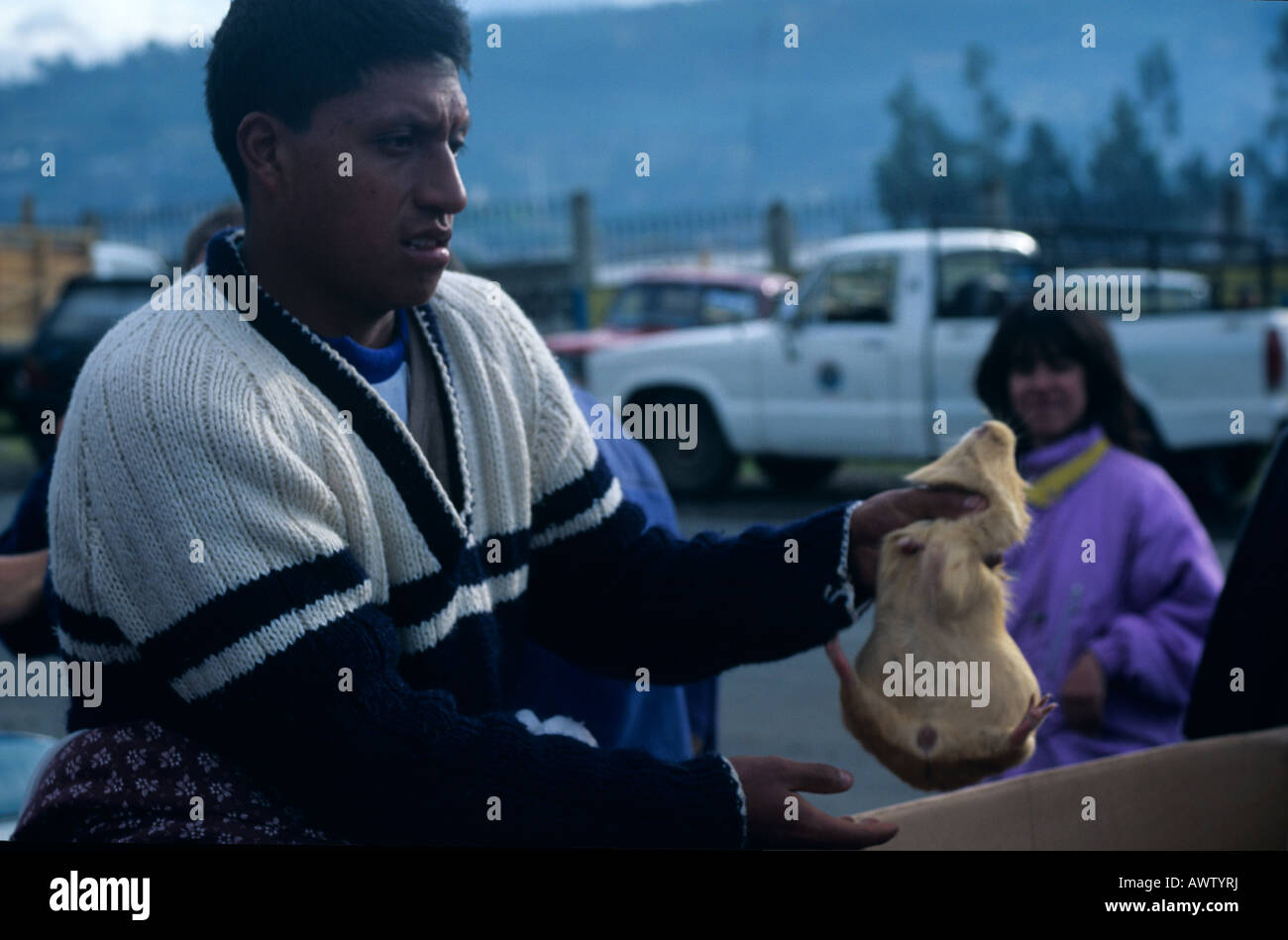 Mercato di Otavalo, Ecuador, un uomo di vendere un porcellino d'India come cibo. Foto Stock