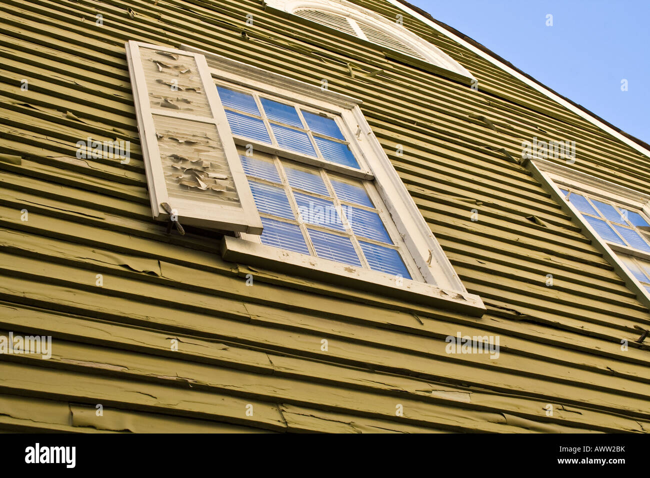 Finestra con un otturatore sul lato di una vecchia casa gialla in Sant'Agostino, Florida, Stati Uniti d'America. Foto Stock