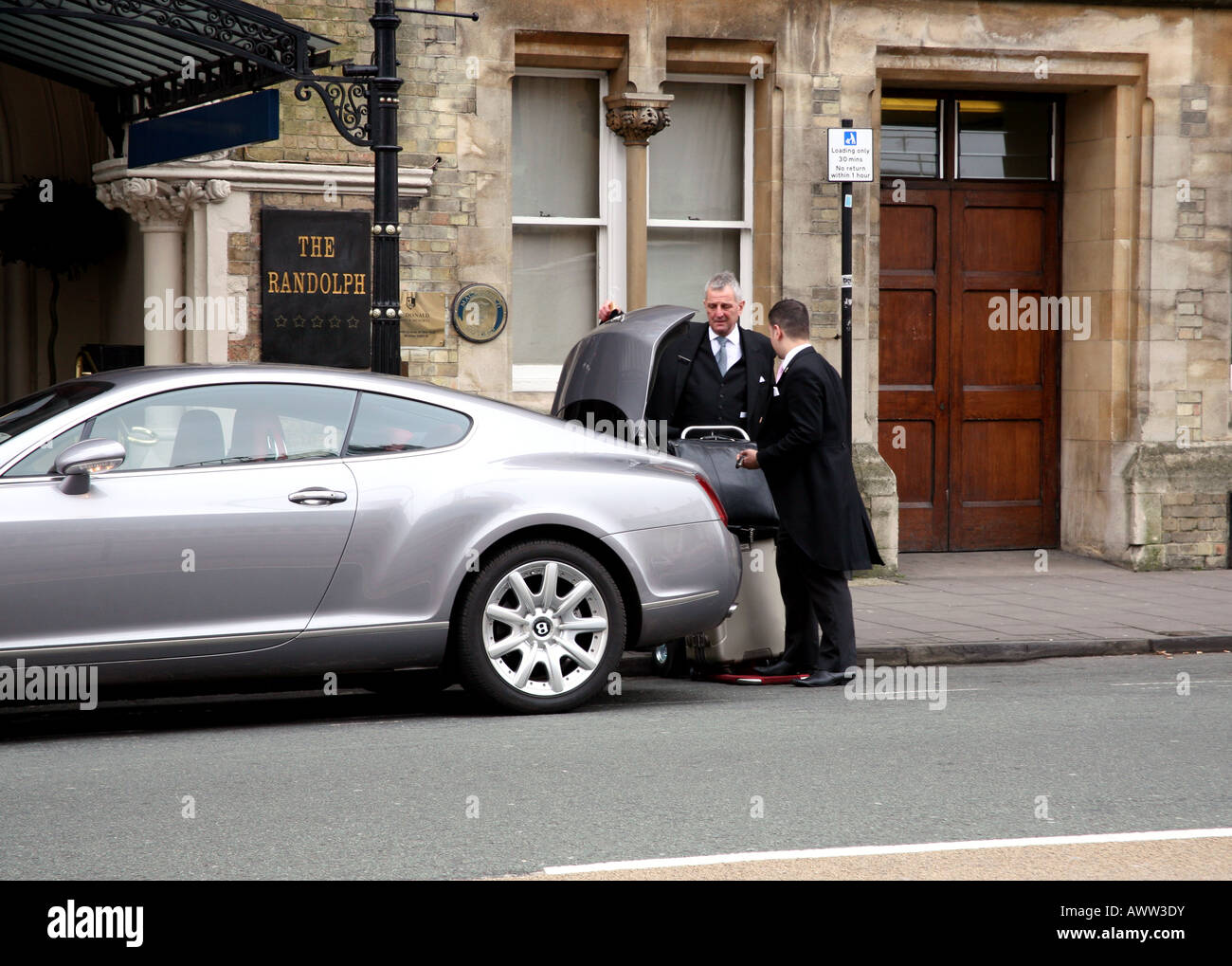 Il personale dell'Hotel il carico del cliente al di fuori di Bentley Randolph Hotel, Oxford Foto Stock