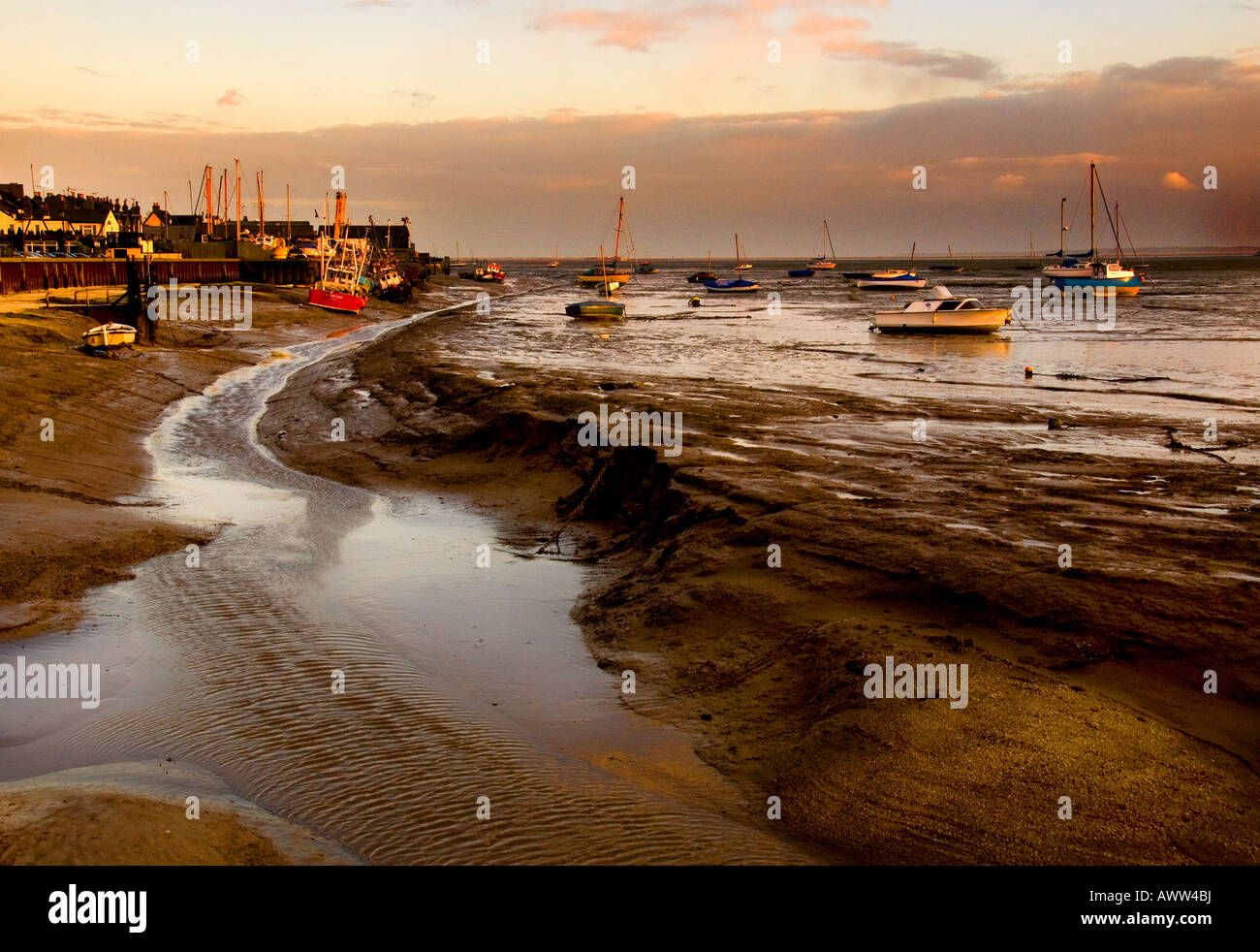 Leigh on Sea - imbarcazioni ormeggiate a bassa marea come il sole tramonta sulla storica Vecchia Leigh sull'estuario del Tamigi, Essex, Regno Unito. Foto Stock